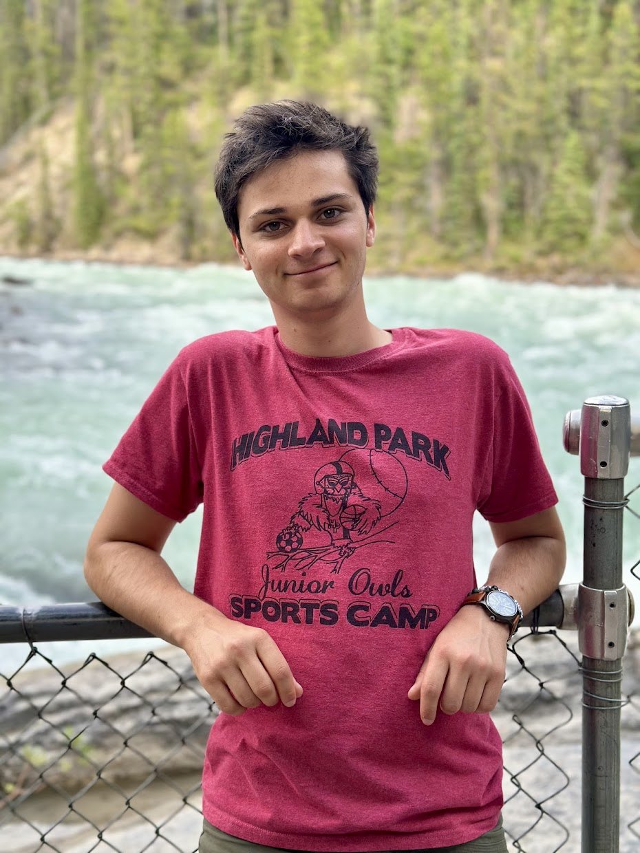Zachary Hale standing at a railing above a glacial river.